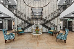 Grand lobby and staircase at The Grove at Trelago senior living in Maitland