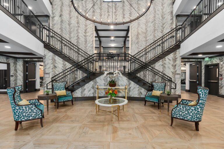 Grand lobby and staircase at The Grove at Trelago senior living in Maitland