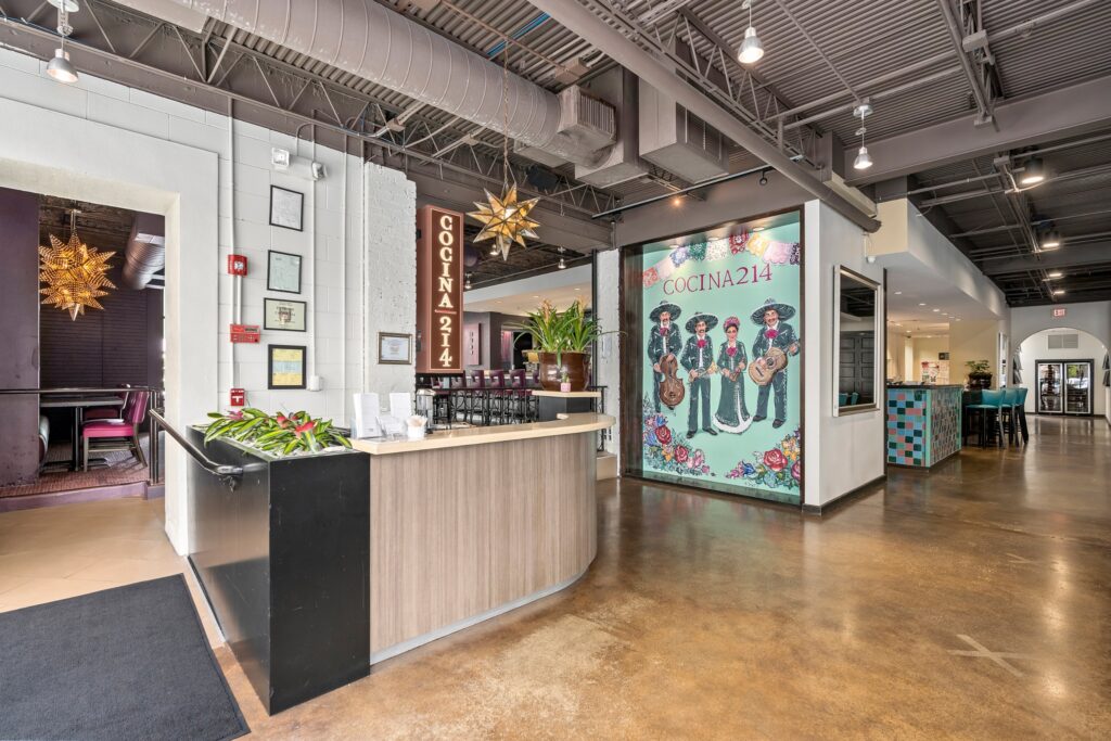 Cocina 214 restaurant interior with host stand and mariachi mural