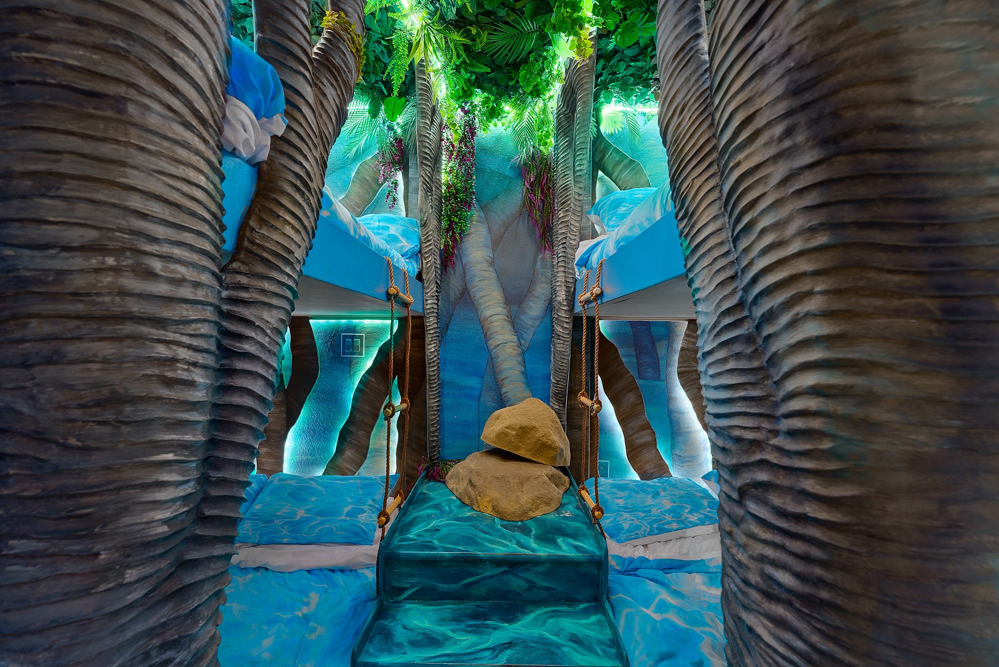 Immersive jungle themed bunk beds with tree trunk surrounds and tropical canopy in a vacation rental — Orlando Home Photography