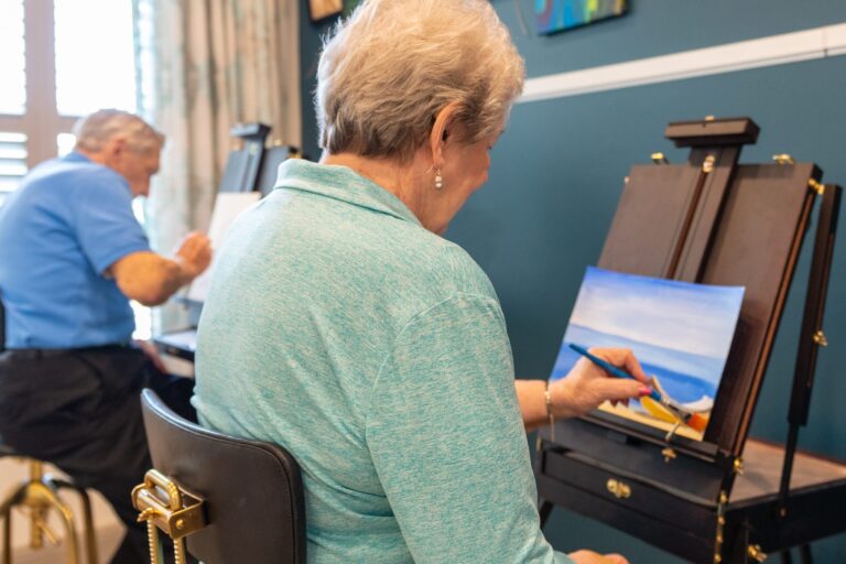 Residents painting during an art class at a senior living community